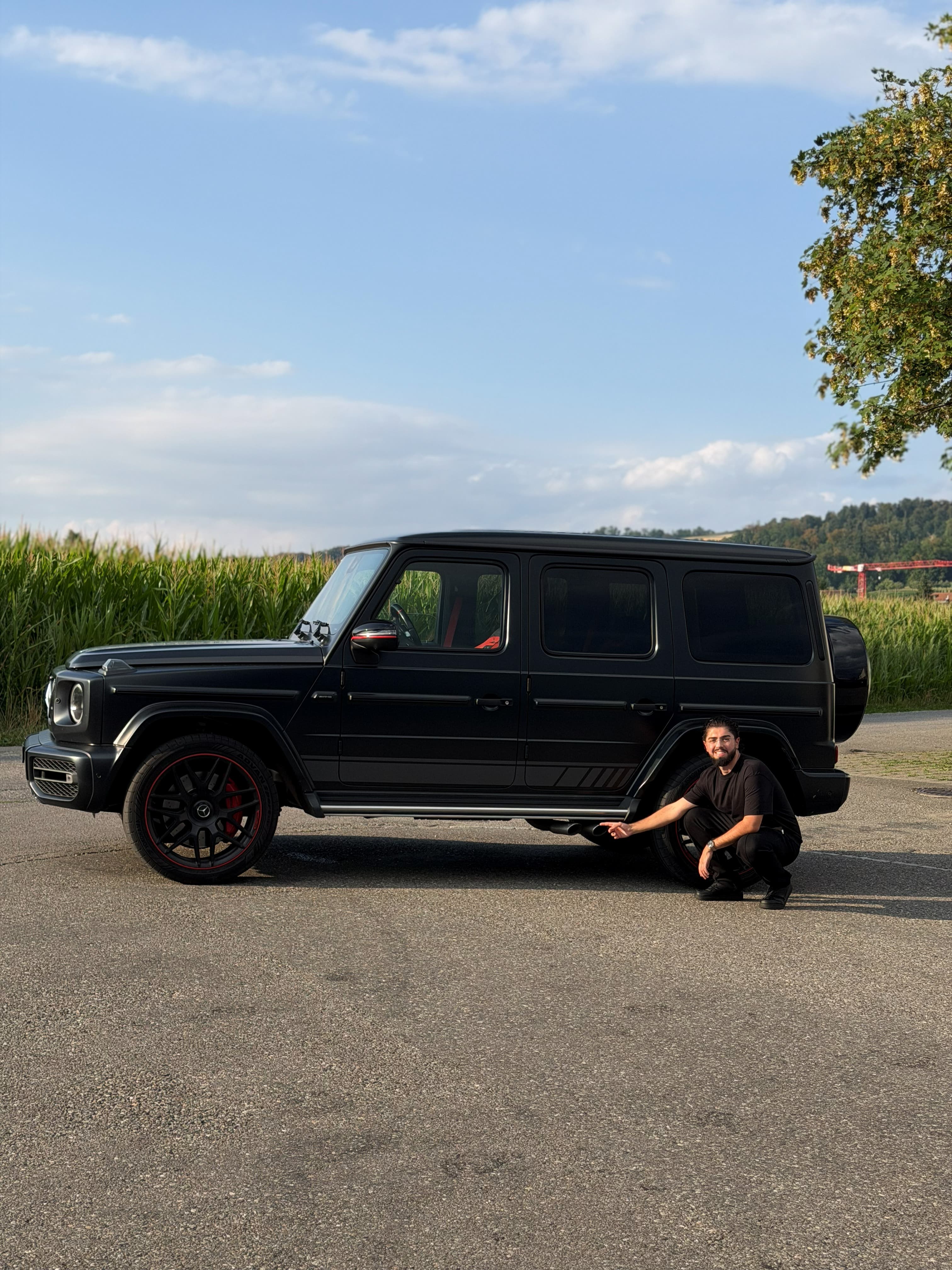 Riwan crouched beside the Mercedes-AMG G63